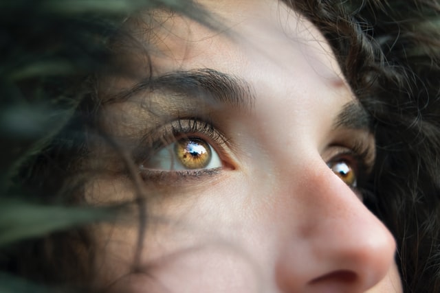 Die Augenpartie einer Person mit hellbraunen Augen