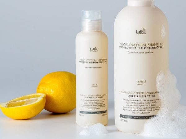 Zwei Flaschen eine Lador-Haarpflege stehen neben einer Zitrone